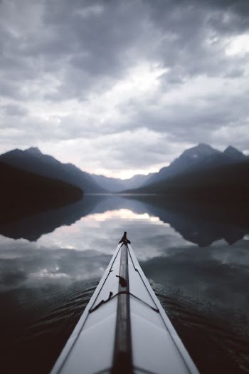grayscale photo of body of water and mountains