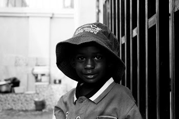 Grayscale Photo of Boy in Polo Shirt With Hat