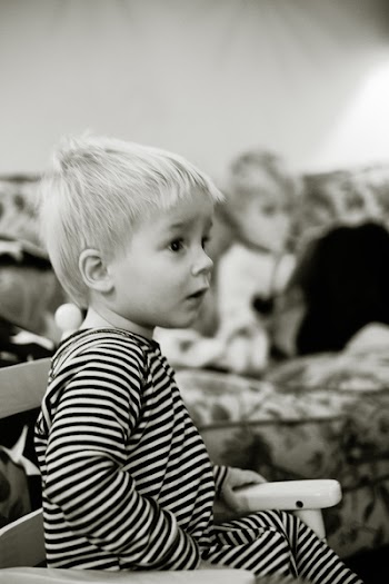 Grayscale Photo of Boy Sitting on Armchair