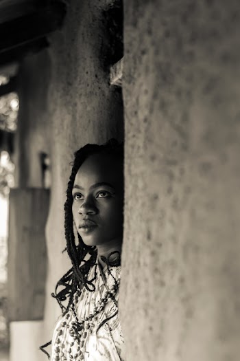 Grayscale Photo of Braided Woman Standing