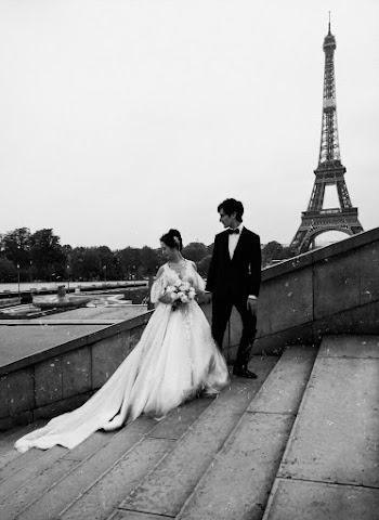 Grayscale Photo of Bride and Groom Standing on Concrete Stairs