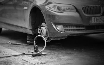 Grayscale Photo of Car Without Wheel