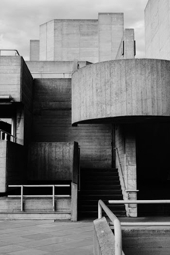 grayscale photo of concrete building and pavement