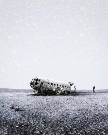 grayscale photo of crushed plane beside person