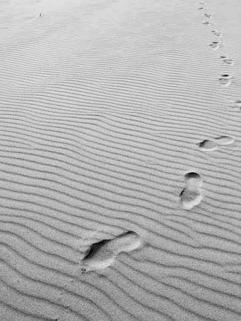 Grayscale Photo of Footprints on Sand