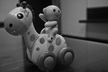 Grayscale Photo of Giraffe and Monkey Plastic Toy on Floor