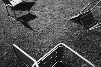 grayscale photo of gray chairs on grass field