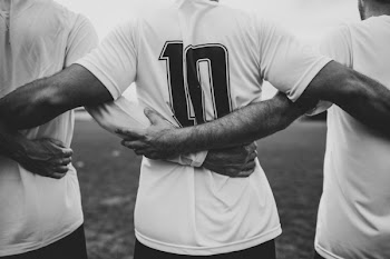Grayscale Photo of Group of Men Holding Each Others Hands