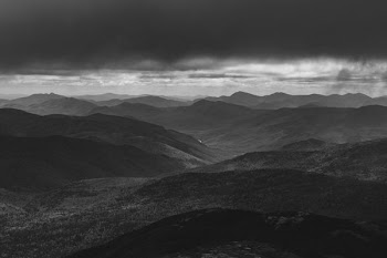 grayscale photo of hill and cloud horizon