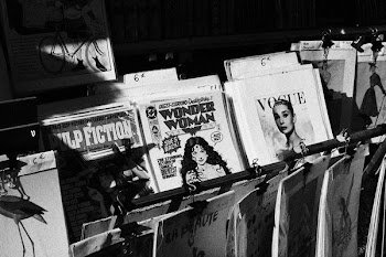 grayscale photo of magazines on rack