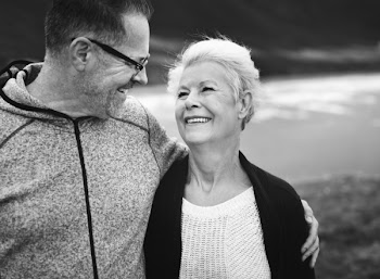 Grayscale Photo of Man and Woman Smiling