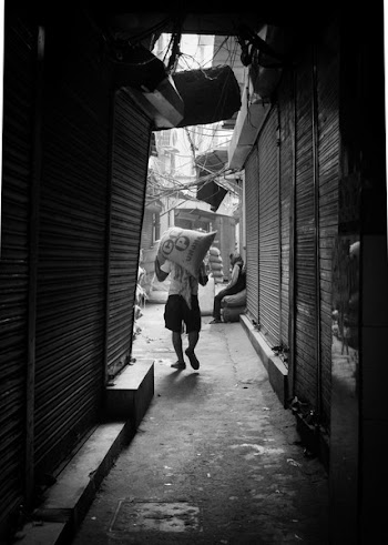 Grayscale Photo of Man Carrying Sack