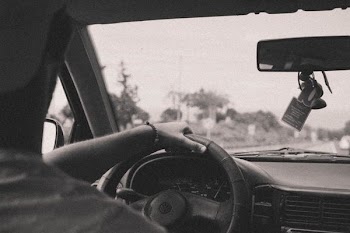 grayscale photo of man driving car