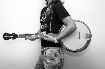 Grayscale Photo of Man Holding Banjo Guitar