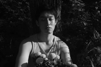 Grayscale Photo of Man in Sleeveless Shirt Leanng against Tree
