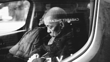 grayscale photo of man inside vehicle sleeping
