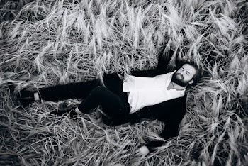 Grayscale Photo of Man Lying on Grass
