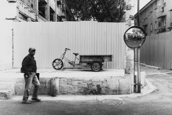 Grayscale Photo of Man Near Bicycle