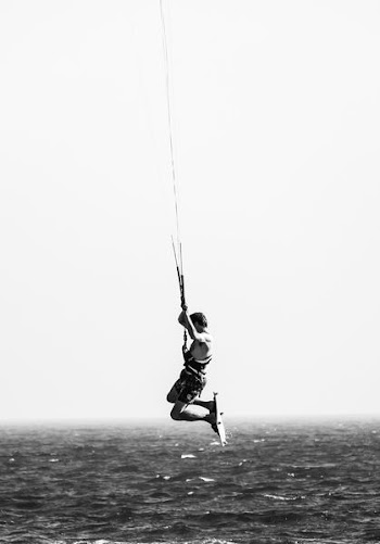 grayscale photo of man on body of water