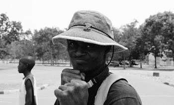Grayscale Photo Of Man Showing Fist Wearing Hat