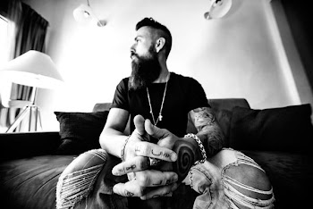 grayscale photo of man sitting on sofa