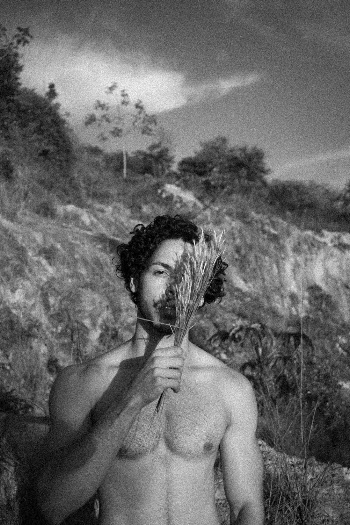 Grayscale Photo of Man Standing Near Rock Plateau