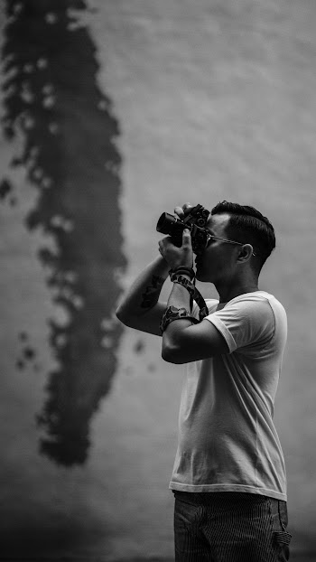 Grayscale Photo of Man Taking Pictures Using a Camera
