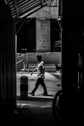 grayscale photo of man walking on street