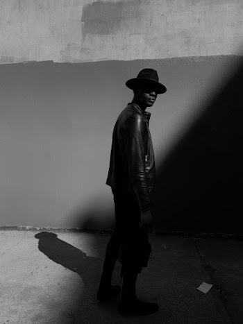 Grayscale Photo Of Man Wearing Black Leather Jacket And Black Pants