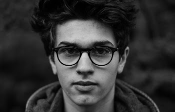 Grayscale Photo of Man Wearing Eyeglasses and Hoodie