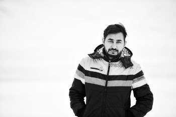 Grayscale Photo of Man Wearing Full-zipped Jacket While Putting His Both Hands Inside Pocket