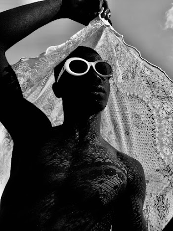 Grayscale Photo of Man Wearing Sunglasses Holding Scarf