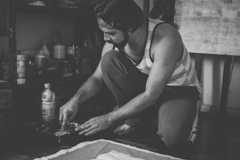 Grayscale Photo of Man Wearing Tank Top Kneeling on Floor