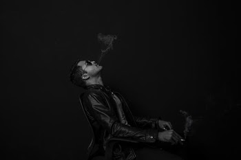 grayscale photo of man with cigarette stick
