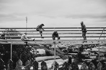 Grayscale Photo of Men Working on a Scaffolding