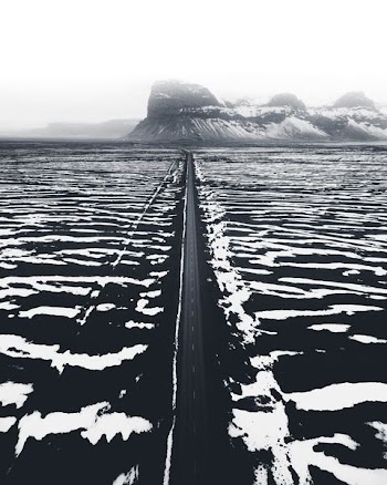grayscale photo of mountain and body of water