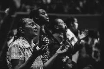 Grayscale Photo of People Raising Hands