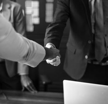 Grayscale Photo of Person Hand Shaking