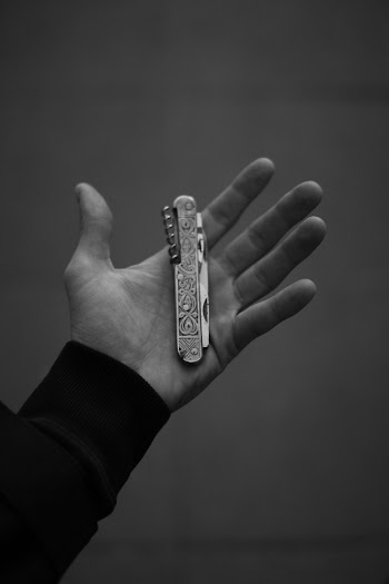 Grayscale Photo of Person Holding A Pen Knife