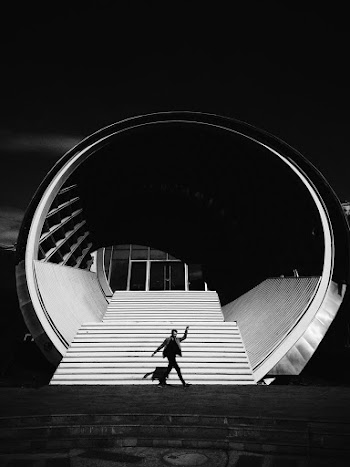 Grayscale Photo of Person in Front of Building