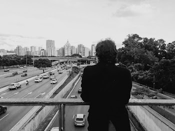 Grayscale Photo of Person on Overpass Looking at Cars