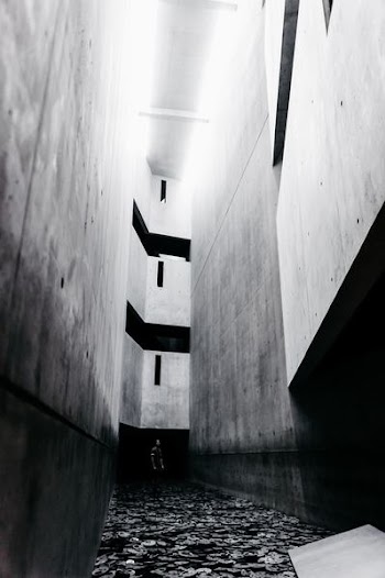 grayscale photo of person standing inside building