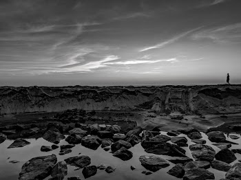 Grayscale Photo Of Person Walking On Rocks