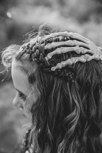 Grayscale Photo of Person Wearing Skeleton Hair Peg