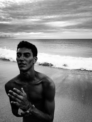 Grayscale Photo of Shirtless Man Standing on the Beach