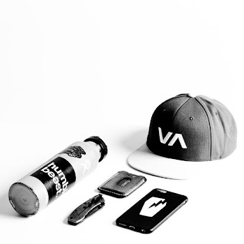 grayscale photo of smartphone and cap