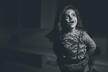 Grayscale Photo of Smiling Girl In Halloween Costume