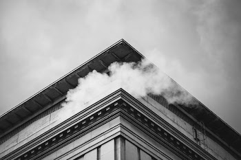 grayscale photo of smoke on top of building