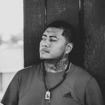 Grayscale Photo of Tattooed Man in Adidas T-shirt Posing While Looking Away
