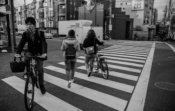grayscale photo of three person on pedestrian lane